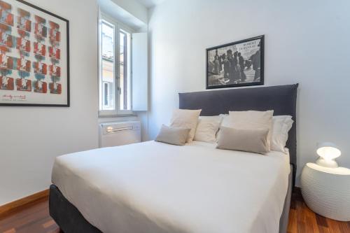 um quarto com uma cama grande e almofadas brancas em Pgrhome Luxury Apartments Croce em Roma