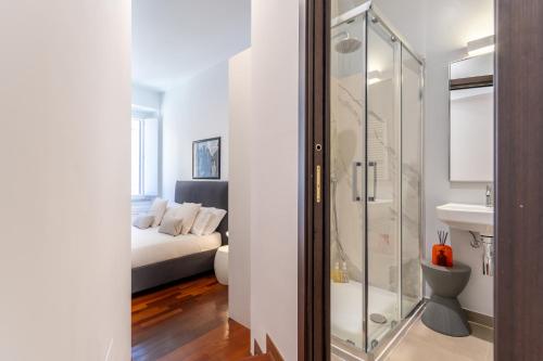La salle de bains est pourvue d'une douche en verre et d'un lit. dans l'établissement Pgrhome Luxury Apartments Croce, à Rome