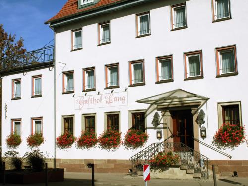 a white building with flowers in front of it at Hotel Gasthof Lang in Balingen