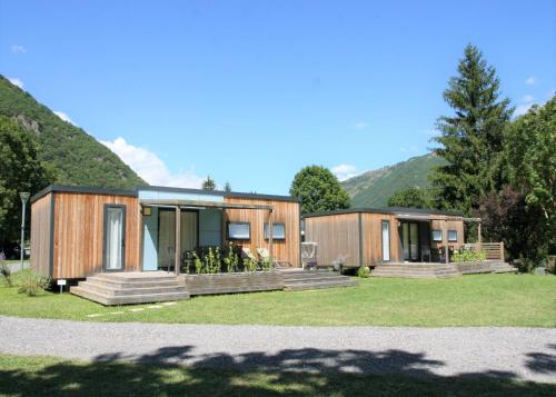 a couple of modular homes with mountains in the background at Camping Pradelongue 