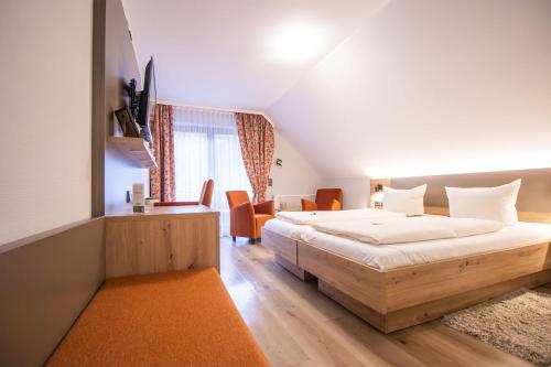 オッペナウにあるHotel - Gasthof Blumeのオレンジ色をアクセントにしたベッドルーム1室(大型ベッド1台付)