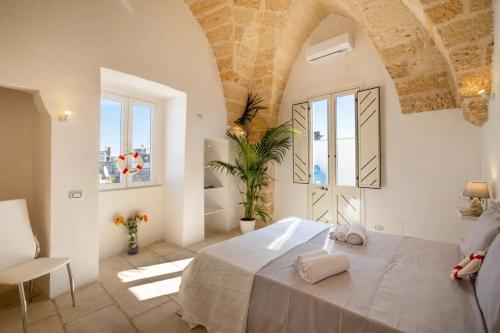 una camera con un grande letto in una stanza con finestre di Armonia Palace In Lecce With Panoramic View a Salice Salentino