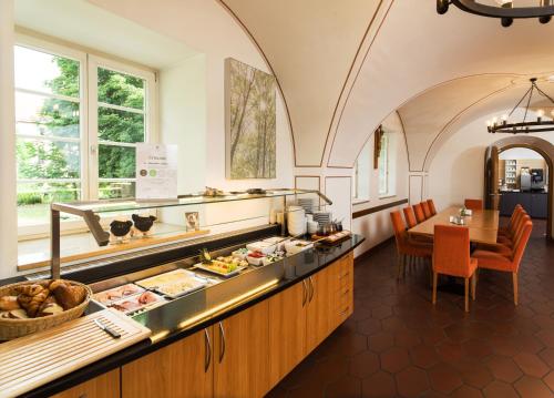 a restaurant with a buffet line with a table at Bildungshaus Neckarelz in Mosbach