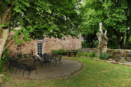 a patio with tables and chairs in a garden at Bildungshaus Neckarelz in Mosbach