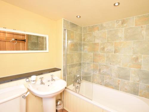 a bathroom with a sink and a toilet and a tub and a sink at 2 Bed in Croyde GCOWS in Marwood