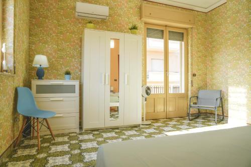 波扎洛的住宿－Casa della Villa Pozzallo，一间卧室配有一张床、一张桌子和一把椅子