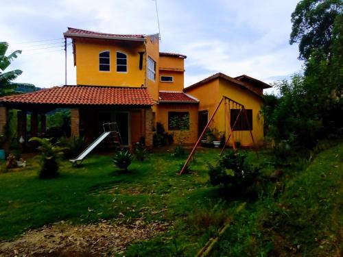 una casa amarilla con un patio delante en Chácara mãos de Gaia, en Bragança Paulista