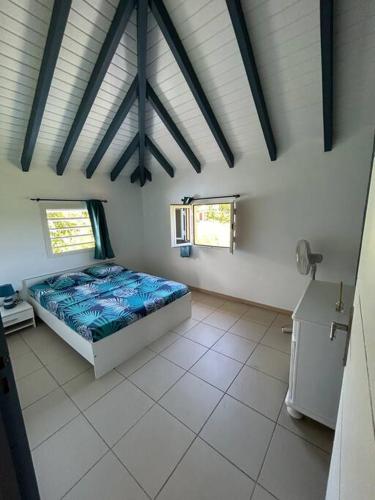 a bedroom with a bed in the middle of a room at Logement Ghenoah in Petit-Canal