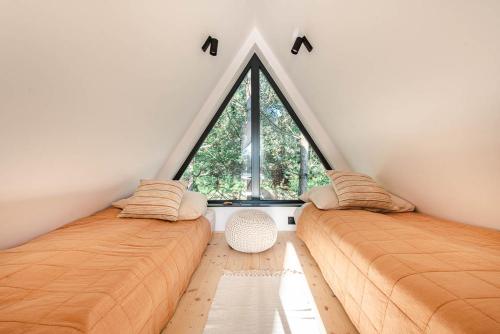 2 camas en una habitación con ventana grande en Budzi nas las en Marcyporęba