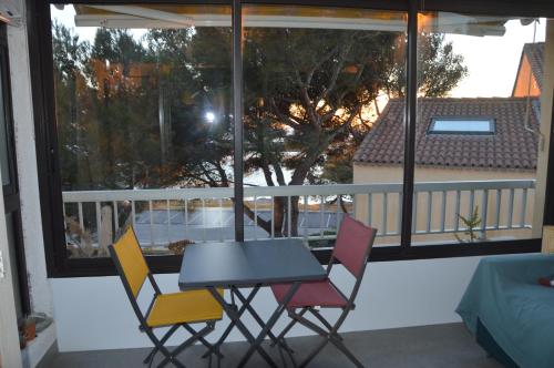 d'une table et de quatre chaises sur un balcon. dans l'établissement Carro duplex les pieds dans l'eau et la tête dans les pins, à Martigues