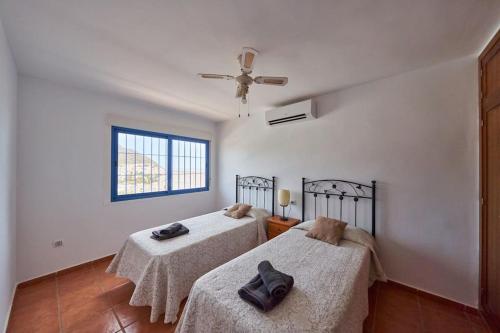 a bedroom with two beds and a ceiling fan at Ricardo in San José