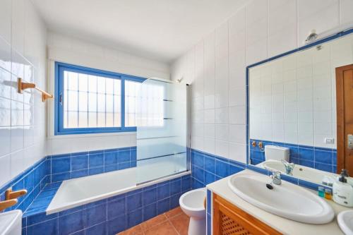 a blue and white bathroom with a tub and a sink at Ricardo in San José