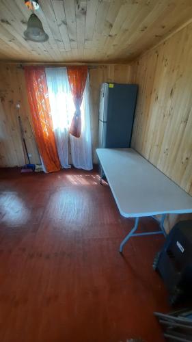 Habitación vacía con mesa y ventana en Cabañas Altos del Poeta, en Isla Negra