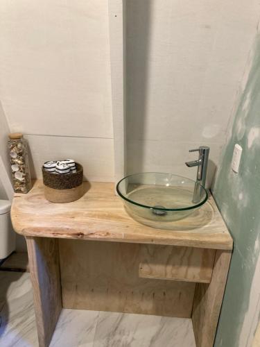 lavabo de cristal en una encimera de madera en el baño en Alpina Liucura cabaña, en Pucón