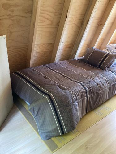 una cama en medio de un ático en Alpina Liucura cabaña, en Pucón