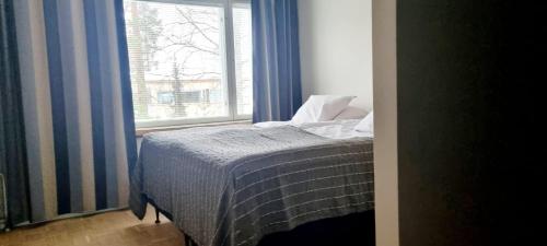 sypialnia z łóżkiem przed oknem w obiekcie Apartment in Tapiola w mieście Espoo