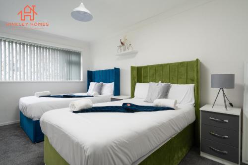 two beds in a room with white and blue at Spacious 2 bedroom-Birmingham/sleeps 8/freeparking in Birmingham