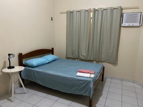 a bedroom with a bed with blue sheets and a window at Apto próximo à Polícia Federal in Manaus