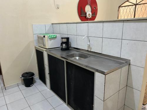 a kitchen with a sink and a microwave at Apto próximo à Polícia Federal in Manaus