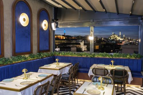 ein Restaurant mit Tischen und Stühlen und Stadtblick in der Unterkunft Glamour Hotel Istanbul Sirkeci in Istanbul