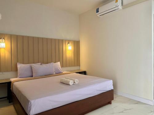 1 dormitorio con 1 cama con 2 toallas en 24 Sleep Resort Khlong Luang Hospital, en Khlong Luang