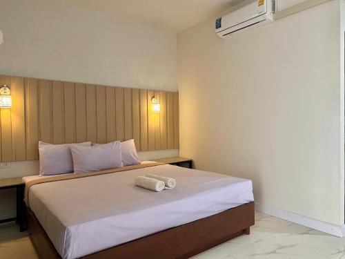 a bedroom with a bed with two towels on it at 24 Sleep Resort Khlong Luang Hospital in Khlong Luang
