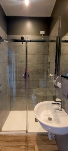 a bathroom with a glass shower and a sink at Al Binario Brescia in Brescia