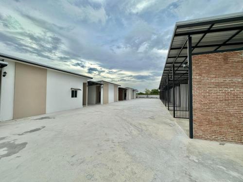 an empty parking lot next to a brick building at 24 Sleep Resort Khlong Luang Hospital in Khlong Luang