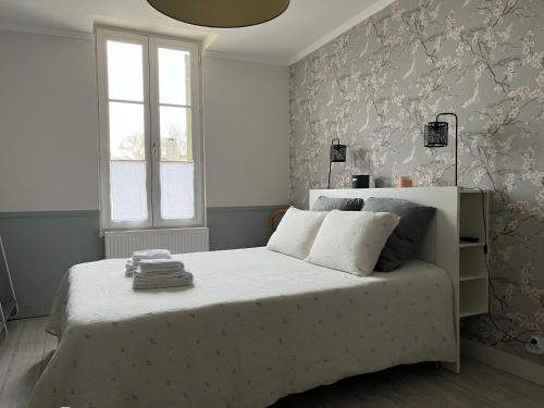 a bedroom with a large white bed with a window at Chambre d'hôtes de La Clie in Saint-Michel-de-Fronsac