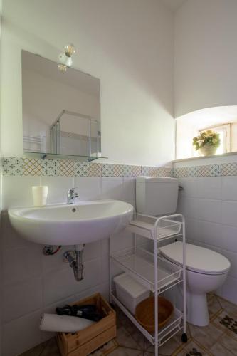 a bathroom with a sink and a toilet and a mirror at Si-Moutique, le Case-grotte degli Avi 2 in Modica