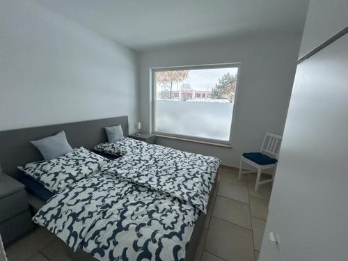 a small bedroom with a bed and a window at Ferienwohnung am Ostseeküstenradweg in Stralsund