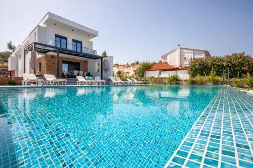 una piscina di fronte a una villa di Megan Luxury villa with private pool a Pefkohori