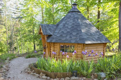 una pequeña casa de madera con techo en un jardín en La Roche aux Fées en Lapte