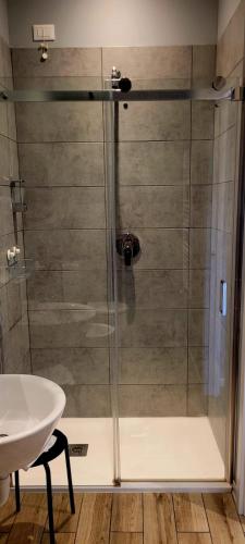 a shower with a glass door next to a sink at Al Binario Brescia in Brescia