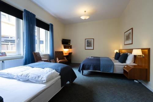 Una habitación de hotel con dos camas y una ventana. en Milling Hotel Gestus, en Aalborg