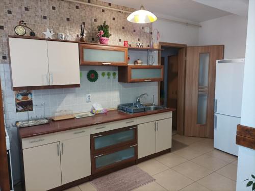 a kitchen with white cabinets and a sink and a refrigerator at Apartament Alex in Alba Iulia