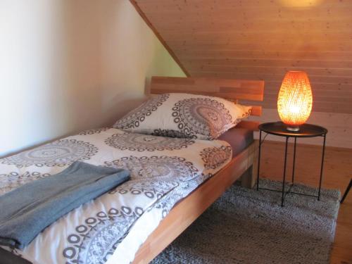 a bedroom with a bed with a lamp on it at #4 Dachstudiozimmer mit 2 Betten und Balkon mit WG Bad Airport nah freies W-Lan in Trunkelsberg