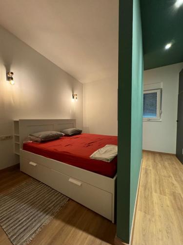 a bedroom with a large bed with red sheets at Barbie's House in Žerava