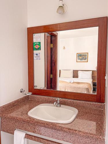 a bathroom with a sink and a mirror at Sunshine Praia Hotel in Porto Seguro