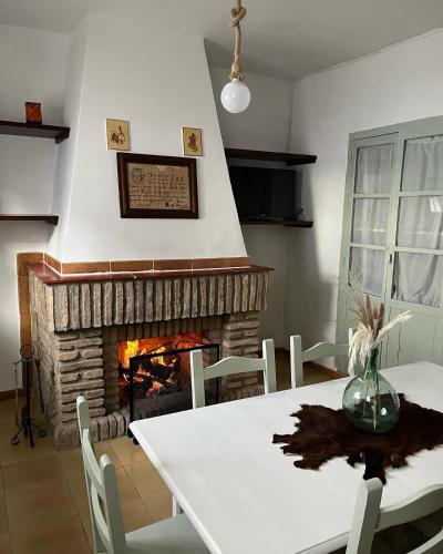 a dining room with a table and a fireplace at La Casilla in Montilla