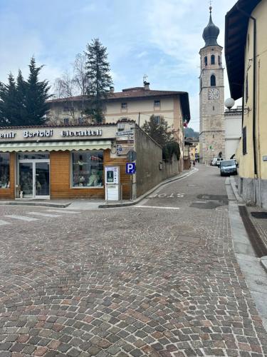a cobblestone street in a town with a clock tower at Appartamento vacanze Piazza in Fondo