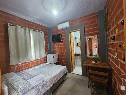 a red brick room with a bed and a mirror at Pousada Vipayu perto da Orla de Alter a apenas 50 metros da praia in Alter do Chao