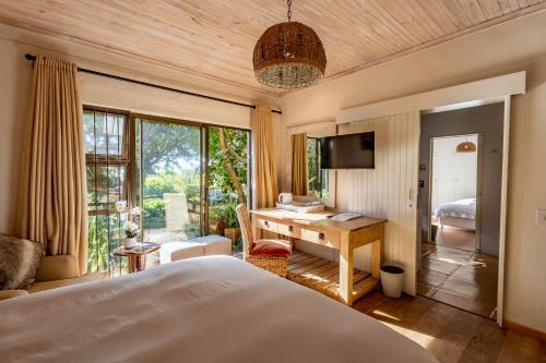 a bedroom with a bed and a desk in a room at Tidal Retreat in Plettenberg Bay