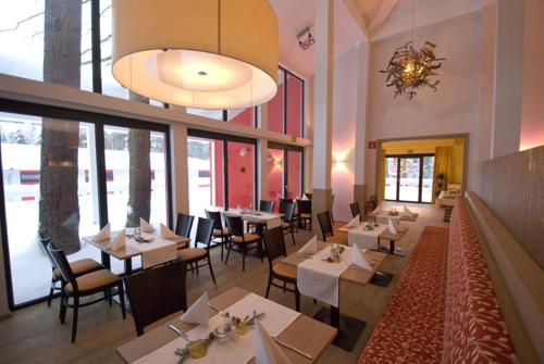 restauracja ze stołami i krzesłami oraz żyrandolem w obiekcie Restaurant Waldmeisterei w mieście Gera
