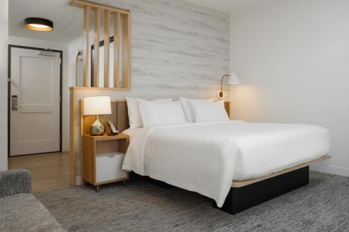 um quarto com uma grande cama branca e uma cadeira em TownePlace Suites by Marriott Chattanooga South, East Ridge em Chattanooga
