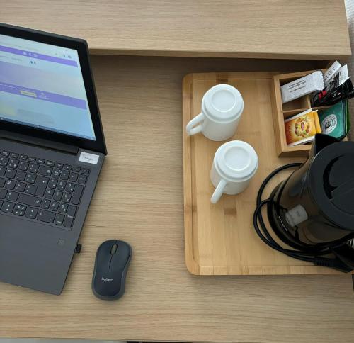 a laptop computer sitting on a desk with a mouse at The Originals Residence, Kosy Appart'hotels Troyes City & Park in Troyes