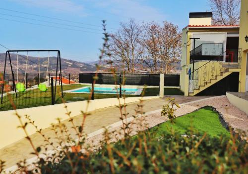 a backyard with a pool and a volley ball court at Casa da Carlota in Cinfães