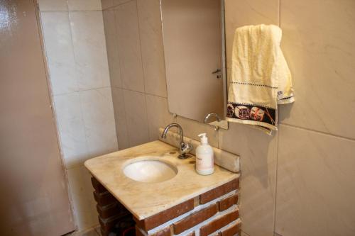 een badkamer met een wastafel en een spiegel bij Chacára Familia Buscapé Oliveira in Araçariguama