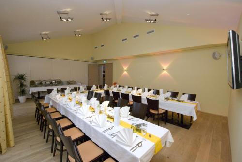 a large room with tables and chairs with white tables and chairs at Restaurant Waldmeisterei in Gera