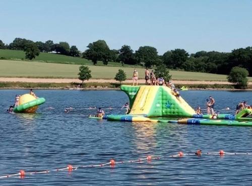 un groupe de personnes sur une rampe gonflable dans l'eau dans l'établissement MAISON LA BURELIERE - holiday home for families, groups, couples, à Gorron